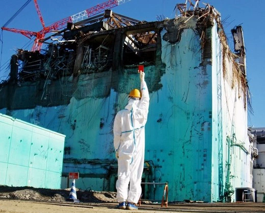 Участник «Chim?Pom» Мидзуно Тосинори поднимает красную судейскую карточку на ядерном реакторе АЭС «Фукусима-1»